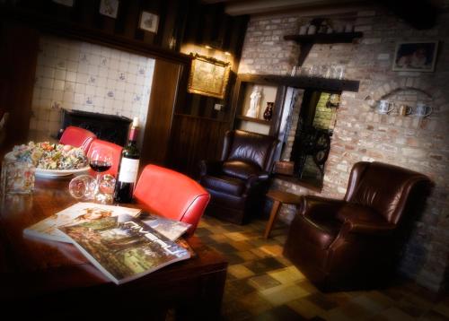 a living room with leather chairs and a table at Hotel De Oude Brouwerij in Mechelen