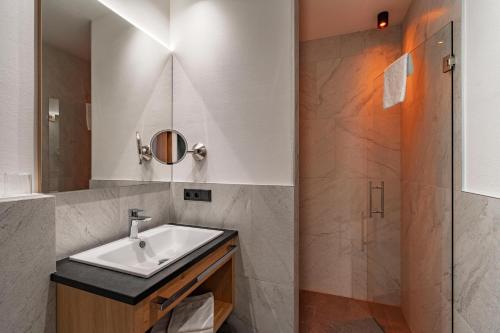 a bathroom with a sink and a shower at Hotel Eller in Solda