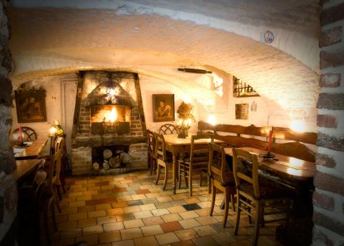 a dining room with a fireplace and a table and chairs at Hotel De Oude Brouwerij in Mechelen