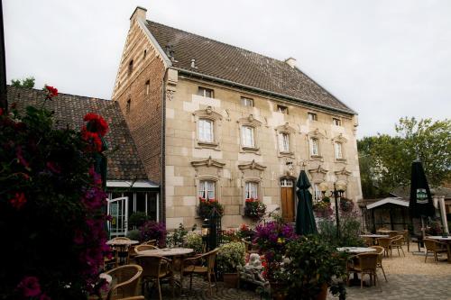 a building with tables and chairs in front of it at Hotel De Oude Brouwerij in Mechelen
