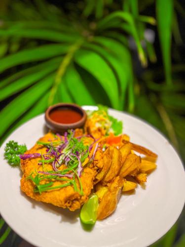 a white plate of food with fries and sauce at Sundaras Infinity Jungle Resort in Dambulla