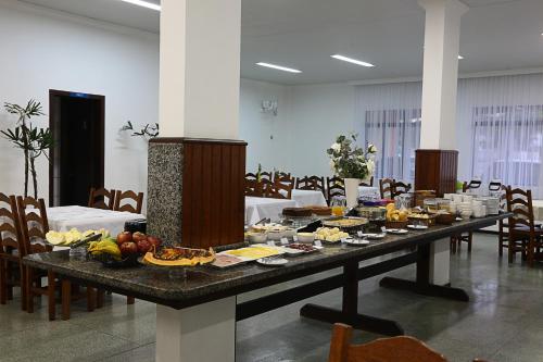 uma mesa longa com comida numa sala em Oceano Hotel de Barra Velha em Barra Velha