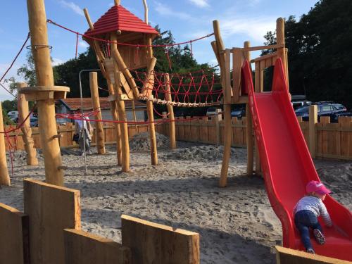 a child playing on a slide in a playground at Vakantiepark Dennenoord in Den Burg
