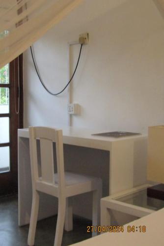 a white desk with a chair next to a wall at Colombo 07 Charming Home Stays in Colombo