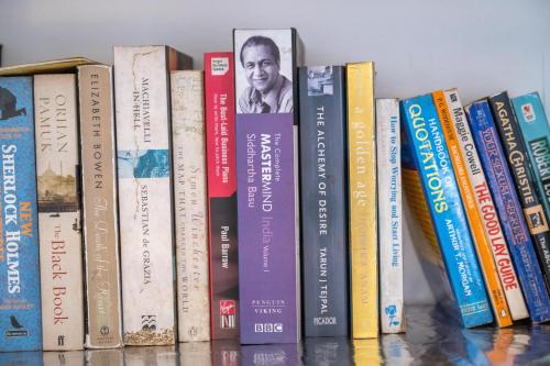 a row of books sitting on a shelf at Colombo 07 Charming Home Stays in Colombo