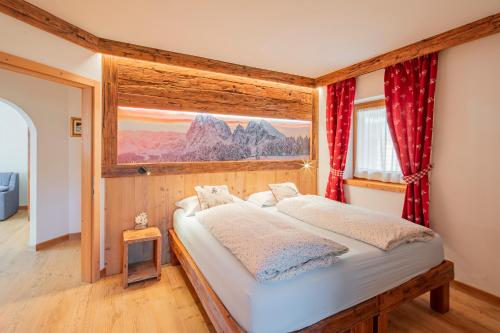 a bedroom with a bed in a room with a window at Cesa La Doe Majons in Campitello di Fassa