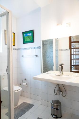 a white bathroom with a sink and a toilet at Colombo 07 Charming Home Stays in Colombo