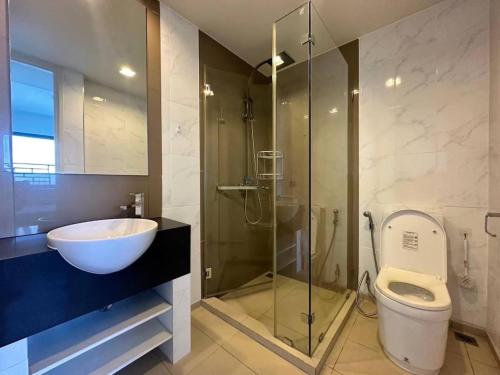 Un baño con lavabo, inodoro y ducha. en Large High Floor, Best Pool and Great Location, en Pattaya South