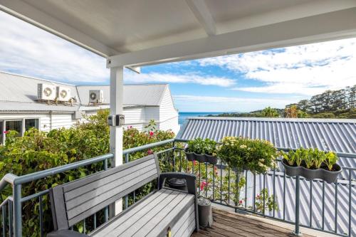 a balcony with a bench and a view of the ocean at Accessible Seaview Unit 3 in Waiheke Island