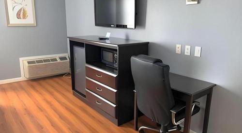 a black desk with a chair and a microwave at Rodeway Inn & Suites Port Arthur - Groves in Port Arthur