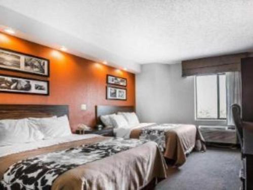 a hotel room with two beds and an orange wall at Sleep Inn Bessemer Helena in Bessemer