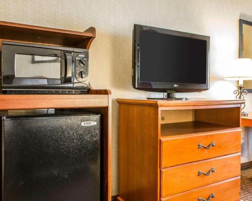 a room with a microwave and a television and a refrigerator at Quality Inn in Sidney