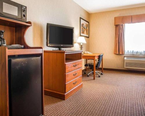 a hotel room with a television and a desk at Quality Inn in Sidney