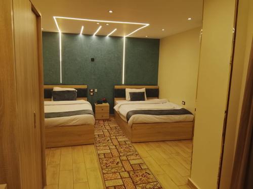 a bedroom with two beds and a green wall at Red Pyramids Hotel in Cairo