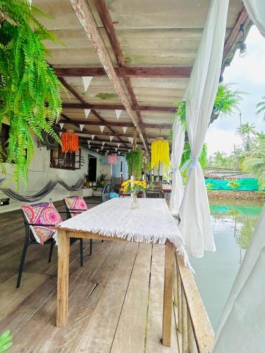 a dining table on a deck next to the water at Lungkluay homestay in Ko Kood