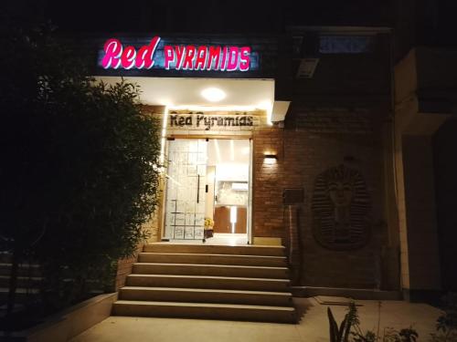 a red neon sign on the front of a restaurant at Red Pyramids Hotel in Cairo