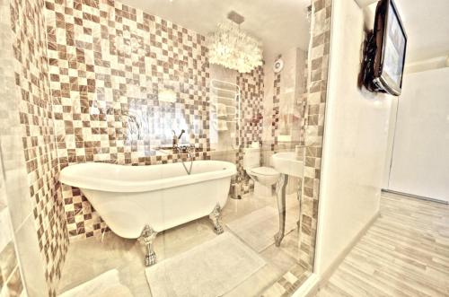 Juozapaviciaus apartments في فيلنيوس: حمام أبيض مع حوض ومغسلة