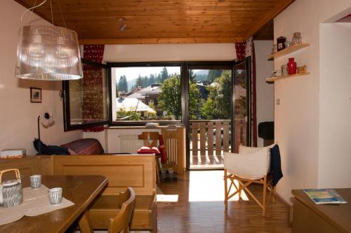 a living room with a dining room table and a window at Casa al Lago di Carezza - Dolomiti in Carezza al Lago