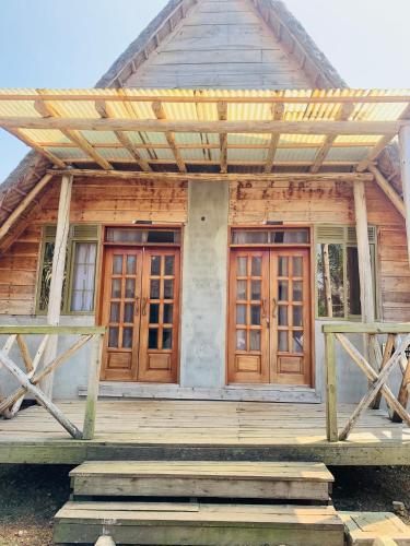 a house with wooden doors and a porch at Bugoma Palms Resort Sand Beach 