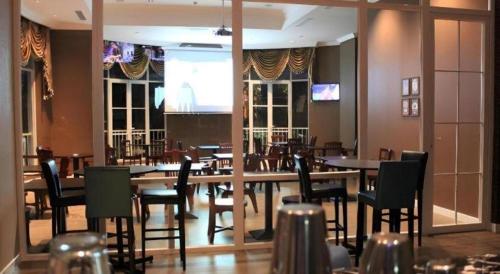 a dining room with tables and chairs in a restaurant at Adimulia Hotel Medan in Medan
