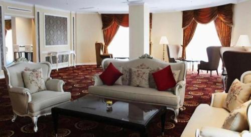 a living room with two chairs and a couch at Adimulia Hotel Medan in Medan