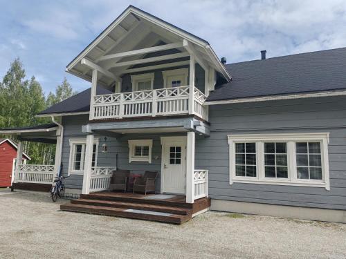 a gray house with a porch and a balcony at Homely Loft in Punkaharju