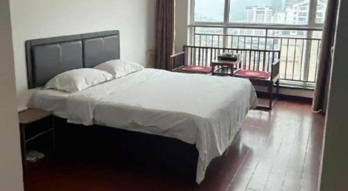 a bedroom with a large bed and a large window at GreenTree Inn Weihai Liugongdao Wharf Qingdao North Road Express Hotel in Weihai