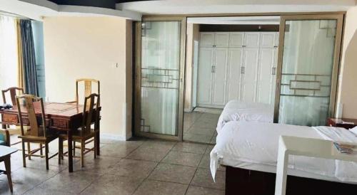 a bedroom with a bed and a table and a desk at GreenTree Inn Weihai Liugongdao Wharf Qingdao North Road Express Hotel in Weihai