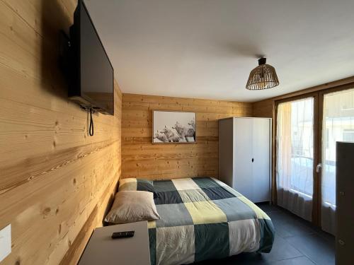 ein Schlafzimmer mit einem Bett und einem Flachbildfernseher in der Unterkunft Appartement au pied des pistes Serre chevalier in La Salle Les Alpes