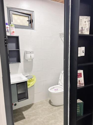 a small bathroom with a toilet and a mirror at Nhà MIO in Khu Chi Lăng