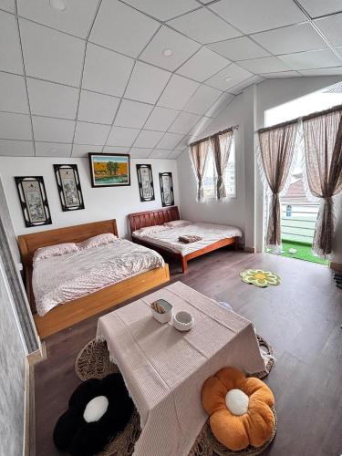 a bedroom with two beds and a table in it at Nhà MIO in Khu Chi Lăng