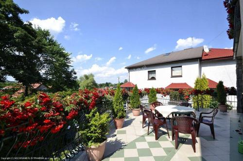 patio ze stołem, krzesłami i kwiatami w obiekcie Villa Almira w Polanicy Zdroju