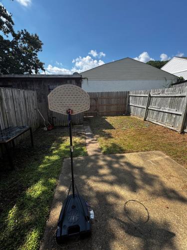a lawn mower sitting in a yard next to a fence at Hampton cozy house near Langley AFB in Hampton