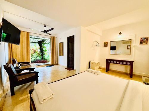 a room with a bed and a desk and a television at Honeywood Holiday Homes in Mahabaleshwar