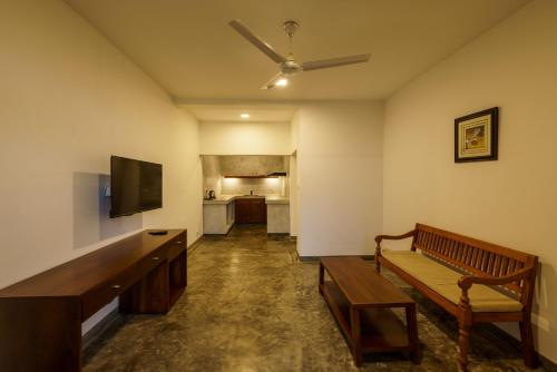 a living room with a couch and a flat screen tv at Golf Resort Par 3 in Kudadeniya
