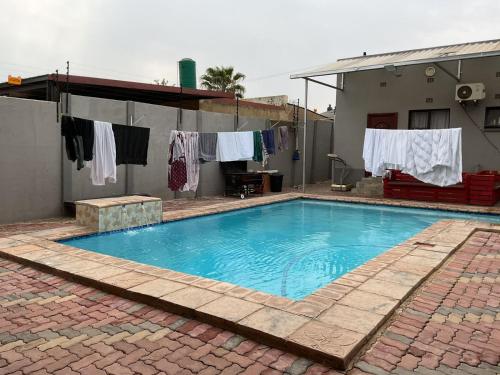 a swimming pool with clothes hanging on a clothesline at northmead lodge in Benoni