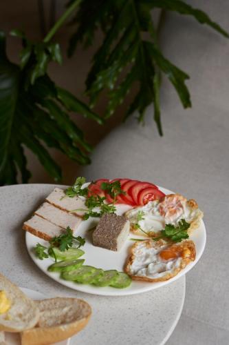 a plate of food with bread and vegetables on a table at J Village Hotel - Triệu Việt Vương in Hanoi