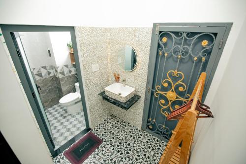a bathroom with a door and a sink and a mirror at Rustic Homestay Bình Dương in Phú Lợi