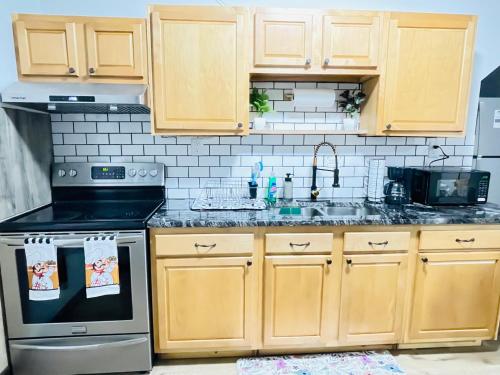 a kitchen with wooden cabinets and a stove top oven at Cozy first floor, 1bed 1bath Near Airport, Cleveland Clinic, Downtown Cleveland in Cleveland