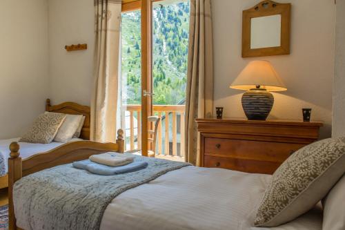 a bedroom with two beds and a window with a porch at Chalet Lucette - bijoux style 200m from the piste in Vaujany