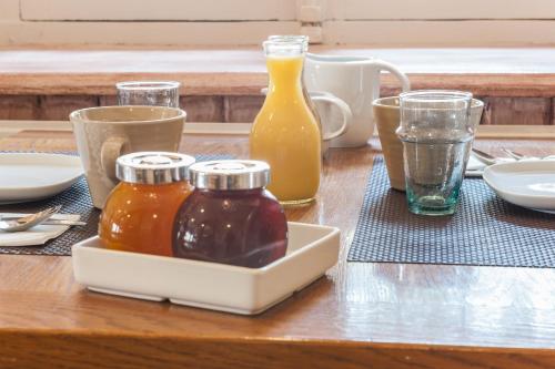 a table with bottles of honey and glasses of orange juice at Le Relais Des Dix Crus - Logis Hôtel in Corcelles-en-Beaujolais