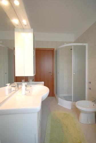 a bathroom with a sink and a shower and a toilet at Guesthouse Meri in Fažana