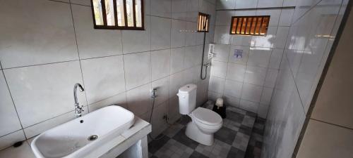 Un baño con inodoro, lavabo y bañera. en Juna Bungalow, en Gili Air