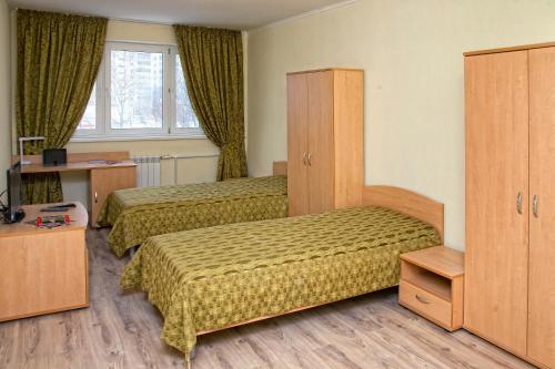 a hotel room with two beds and a cabinet at Stargorod Apart-Hotel in Kaluga