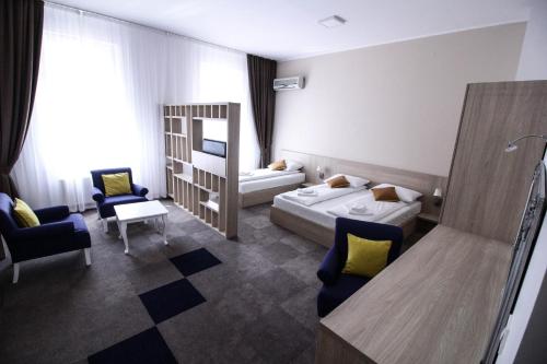 a hotel room with two beds and two chairs at Hotel Story in Sarajevo