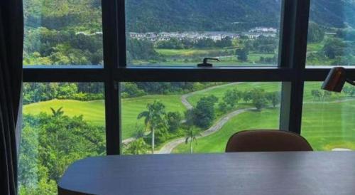 a window view of a golf course from a table at Zhuhai Hongsanyi Hotel in Zhuhai