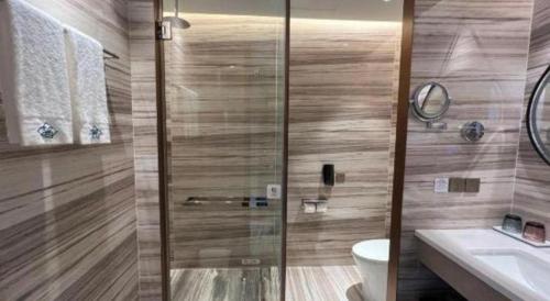 a bathroom with a shower and a toilet and a sink at Zhuhai Hongsanyi Hotel in Zhuhai