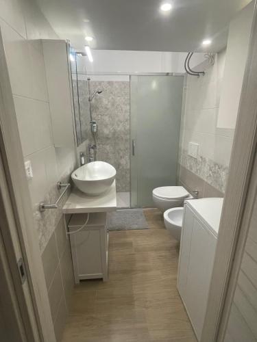 a bathroom with two toilets and a sink and a shower at Small apartment in center in Montesilvano