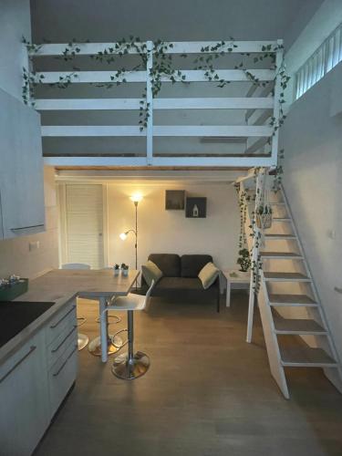 a living room with a stairs leading to a loft at Small apartment in center in Montesilvano