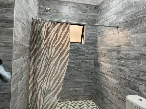a shower with a shower curtain in a bathroom at northmead lodge in Benoni
